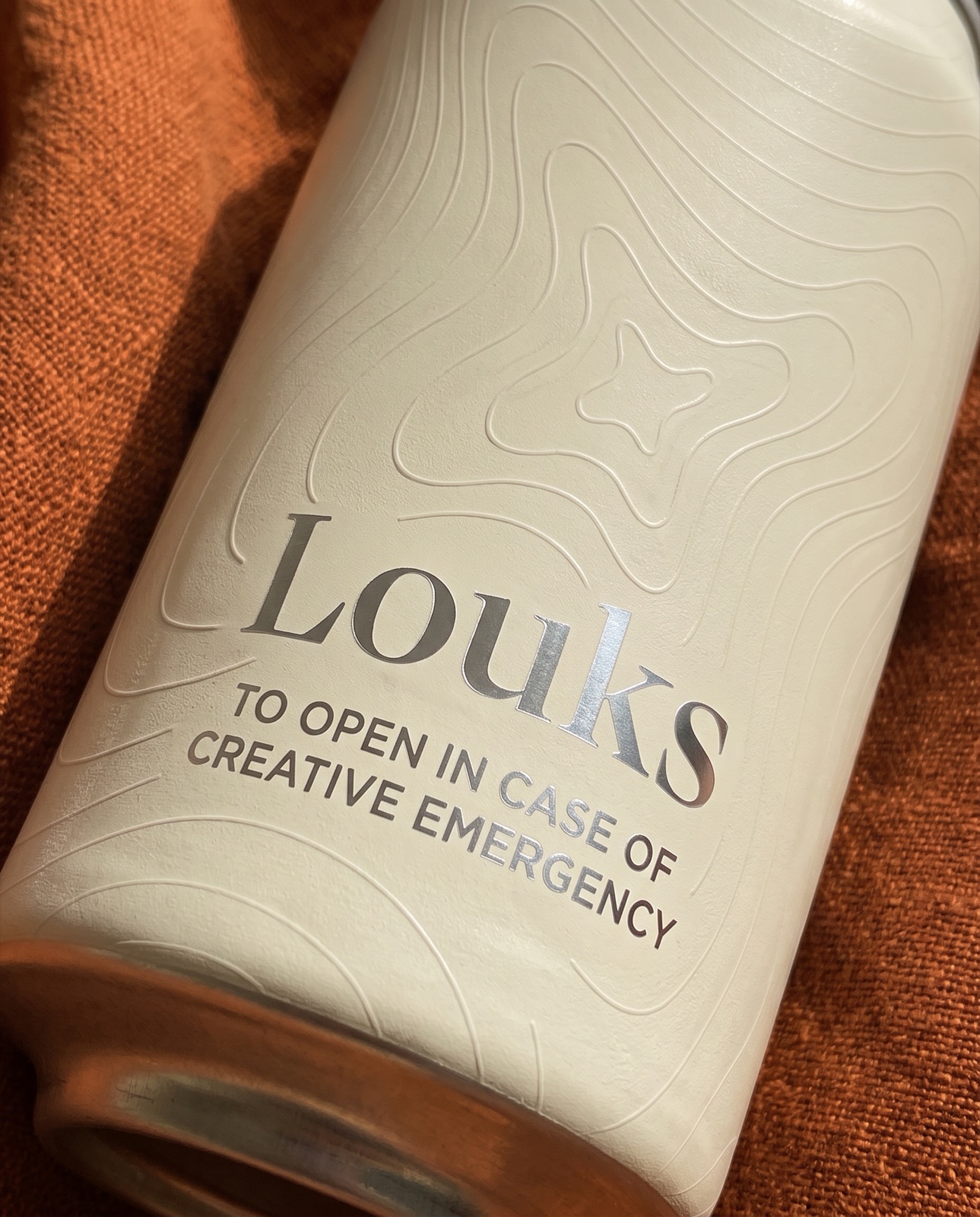 Gros plan sur le nom Louks : les lettres révèlent l’aluminium brossé.